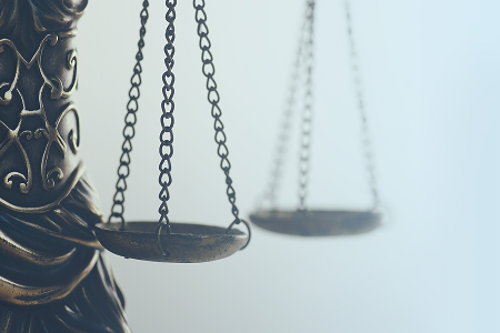 Close-up of scales of justice representing the comparison of legal standards in civil and criminal cases.