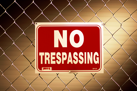 Red no trespassing sign on fence